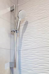 close up view of corner of shower stall with shower head holder