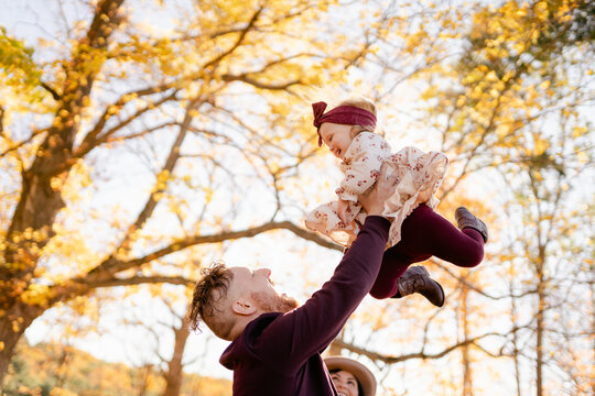 Father Swimming Baby Gril Up In The Air