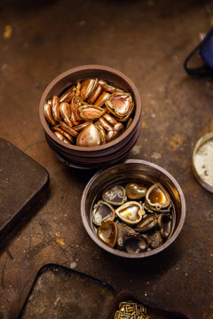 A bowl of pendant locket metal pieces ready to be assembled.