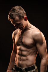 Naklejka premium Studio shot of muscular topless military man on black background