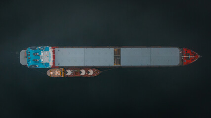 Top-view of two cargo ships like a child and it's parent