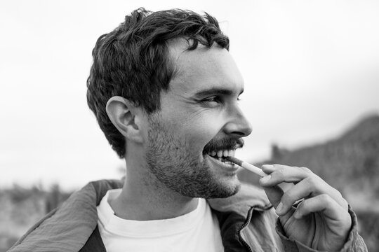 Guy Biting End Of Cigarette