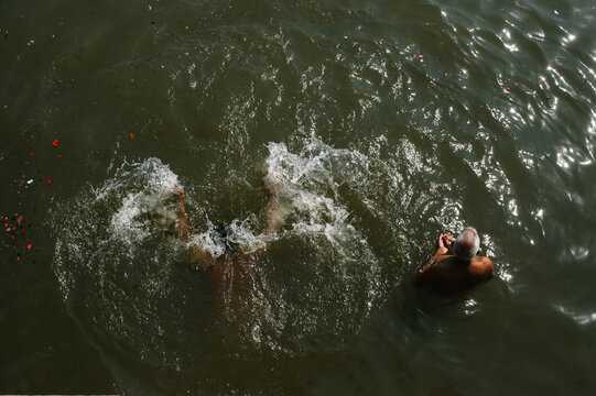 Two Men Praying To Sun in the Ganges river Of Varanasi, India