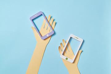 Two papercraft hands with smartphone frames.