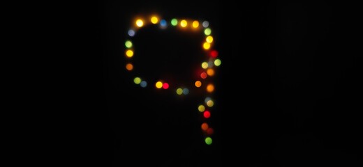 Closeup of Number nine, (9) made with multicolored blurred bokeh Christmas lights in a isolated black background with copy space