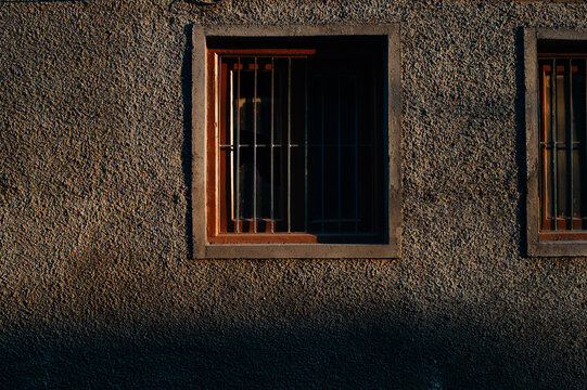 Window with metal bars lit by sunset