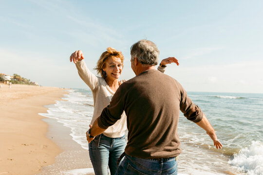happy mature couple giving a hug on the beach