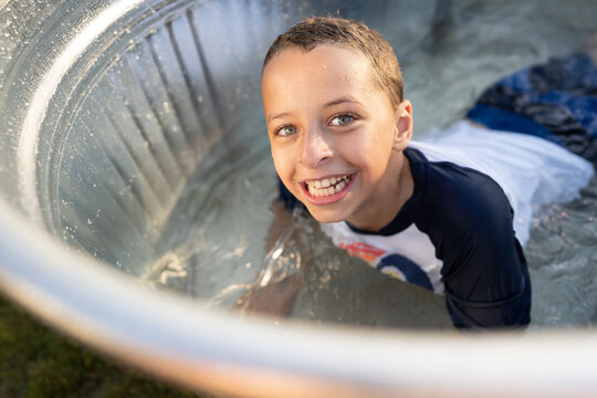 Boy in pool smiles at viewer