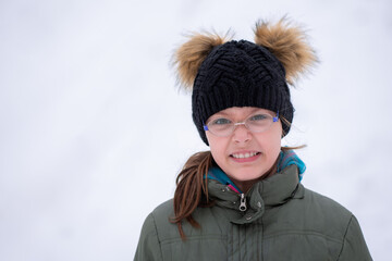 Girl enjoying an outdoors snowy winter’s day. Winter portrait of a girl.
