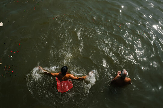 Two Men Praying To Sun in the Ganges river Of Varanasi, India