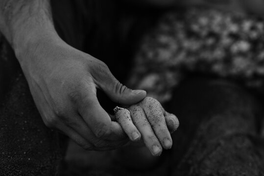 monochrome close up of young couple engaged at the beach