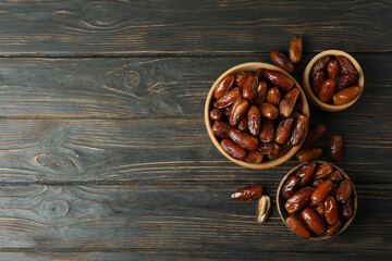 Obraz na płótnie Canvas Bowl with dried dates on wooden table