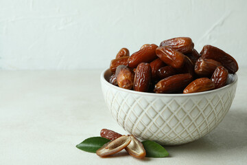 Bowl with dried dates on white textured table