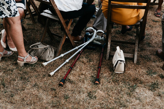 older people get together outdoors, crutches on the floor