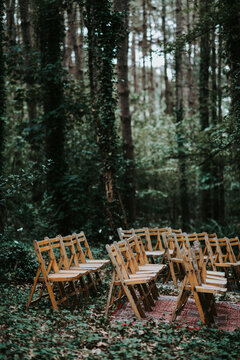 wooden folding chairs and vintage carpets in the woods for wedding