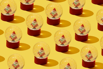 santas wearing face mask in snow globes