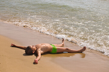 child swims in the sea waves on the beach