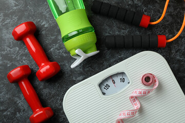 Weight loss accessories on black smoky background, top view