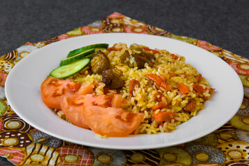 Hot traditional dish pilaf of the East. Served dish with rice on the table.