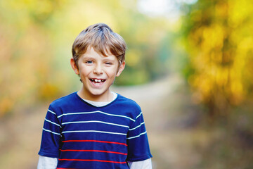 Portrait of little cool kid boy in forest. Happy healthy child having fun on warm sunny day early autumn. Family, nature, love and active leisure.