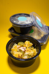 fruit salad in a container on a yellow background