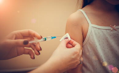 Doctor vaccinates child to stop coronavirus and other pandemic diseases. Concept fight against virus covid-19 corona virus. Syringe in a hand of a woman.