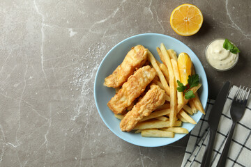 Concept of tasty eating with fried fish and chips on gray textured table