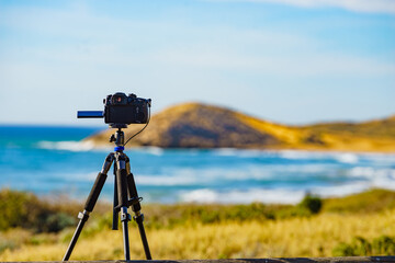 Camera taking picture of sea coast landscape