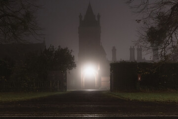 A spooky Victorian building and tower. On a foggy, winters night.