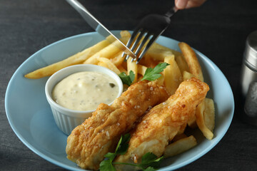 Cutlery over the fried fish and chips, close up