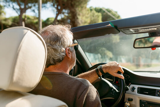 Mature men driving a convertible car during summer