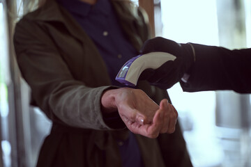 Female traveller having her temperature checked with a contactless thermometer