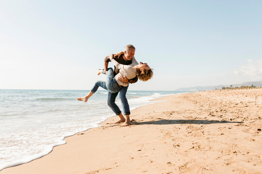 mature couple dancing and hugging at the beach