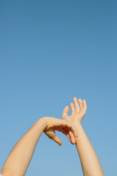 Woman's hands over blue sky