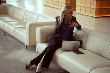 Obraz premium Business woman looking happy receiving good news on the phone
