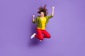 Fototapeta na wymiar Full size photo of young crazy excited smiling funky girl jumping in victory success isolated on violet color background
