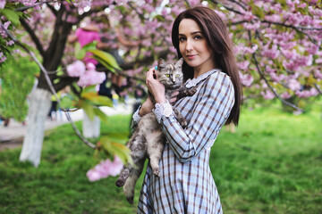 Happy smiling woman with cat on natural background