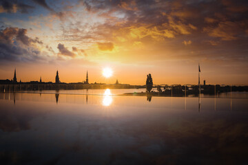 Naklejka premium Morning sunrise shot of old Riga panorama with dramatic sky and reflections