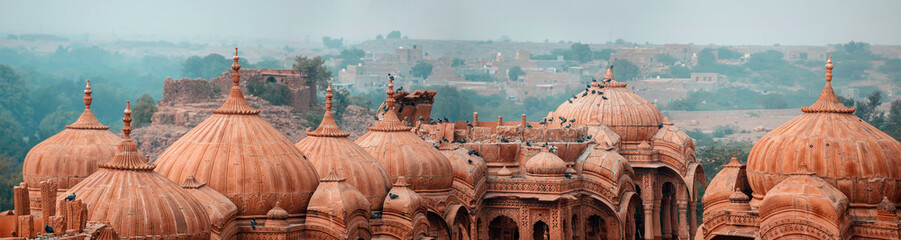 Fototapeta The royal cenotaphs of historic rulers, also known as Jaisalmer Chhatris, at Bada Bagh in Jaisalmer, Rajasthan, India. Cenotaphs made of yellow sandstone at sunset obraz