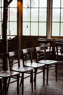 Empty wooden chairs in a row decorated for Christmas with pine leaves and bow