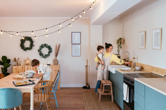 Mom and kids baking Christmas cookies at home - Powered by Adobe