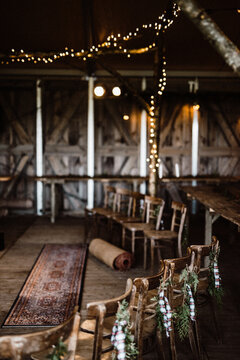 Barn with chairs decorated for Christmas with flowers and string lights