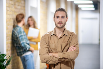 Young bearded man standing in the corridor and looking serious