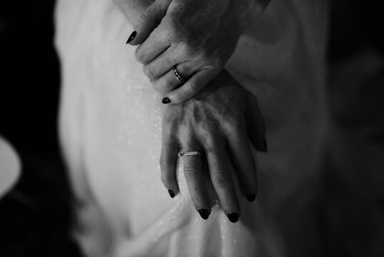 monochrome image of bride holding hands on knees
