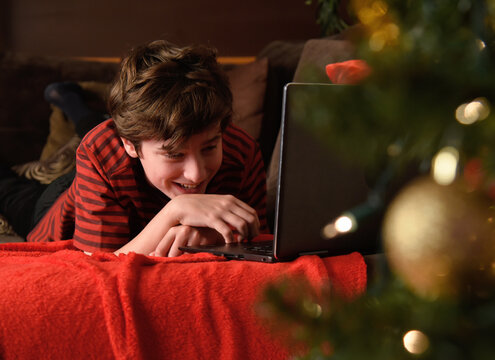 Happy Boy Laughing on Couch with Computer