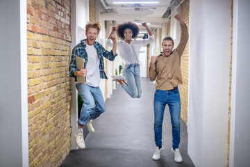 Young people looking happy and jumping in the corridor