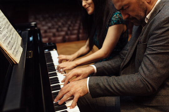Man and woman, playing a piano