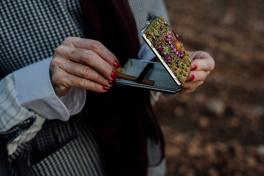 Senior woman smoking at olive grove with flamenco attitude.