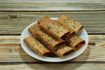 Pile of Thai sweetmeat made of flour, coconut milk and egg serving on the plate. Famous traditional sweet dessert in Asian market. 