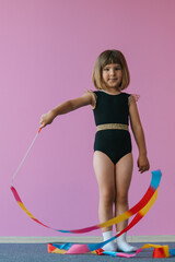 Obraz premium Aesthetics of gymnastics. Pink, black and gold colors. Rainbow ribbon